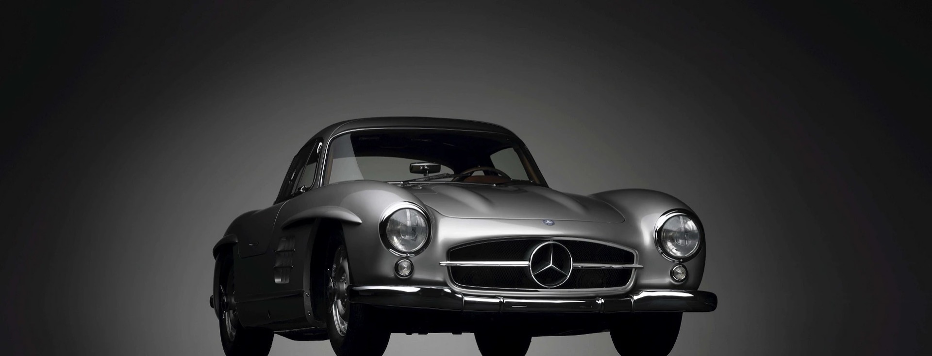 Silver Mercedes-Benz 300 SL Gullwing coupé photographed from the front in a studio