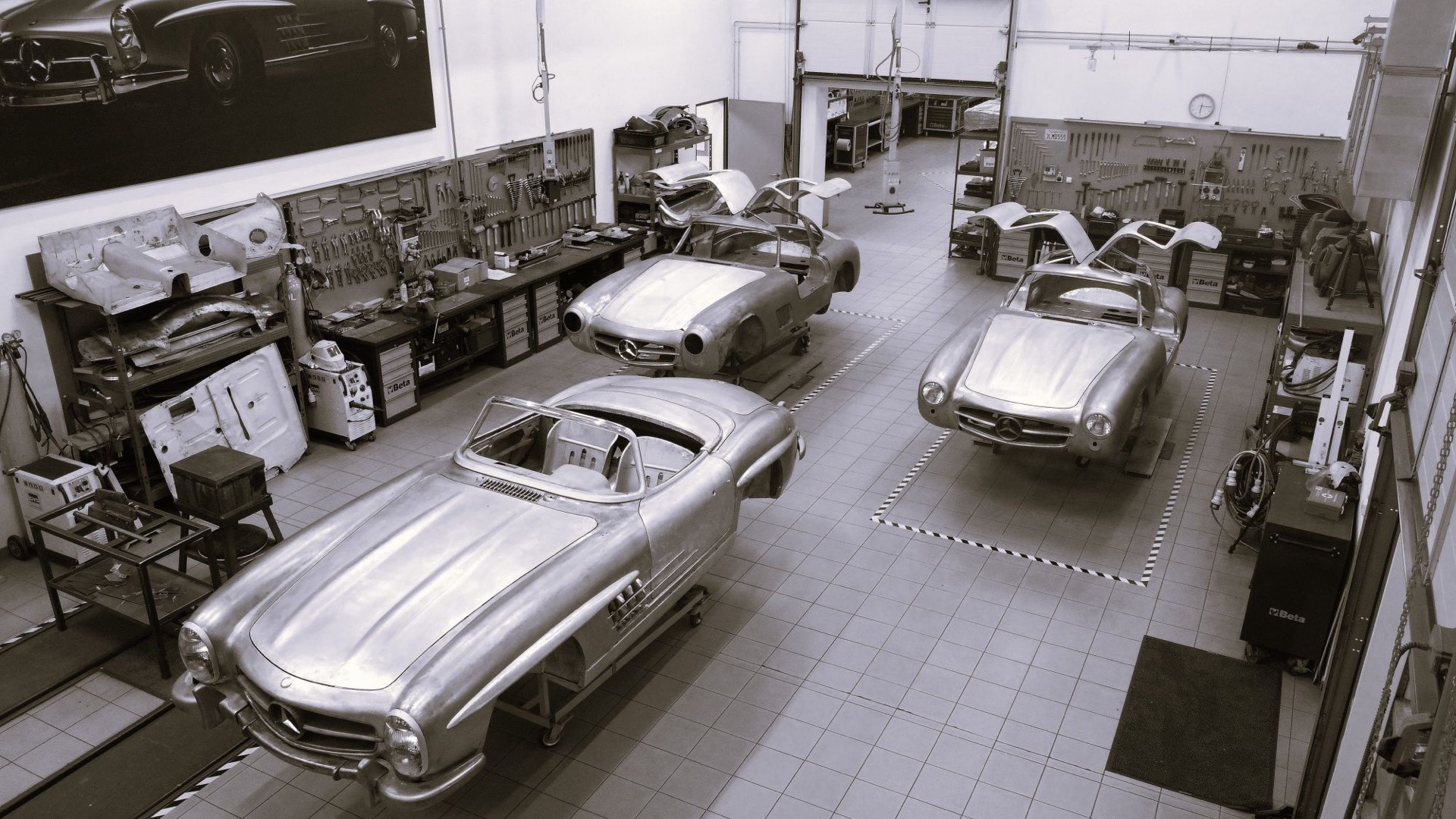 Black and white view from above of three 300 SL bodies in the workshop, two Gullwing coupés and a roadster