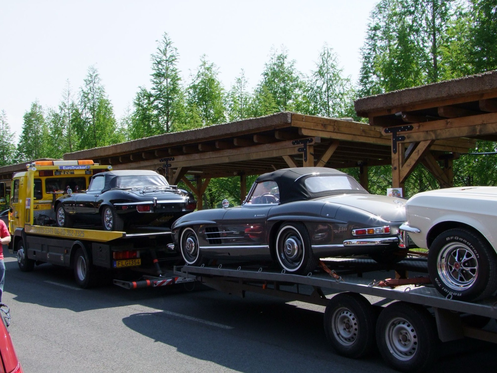 The 300 SL on a car transporter next to other classic cars on the way to the event