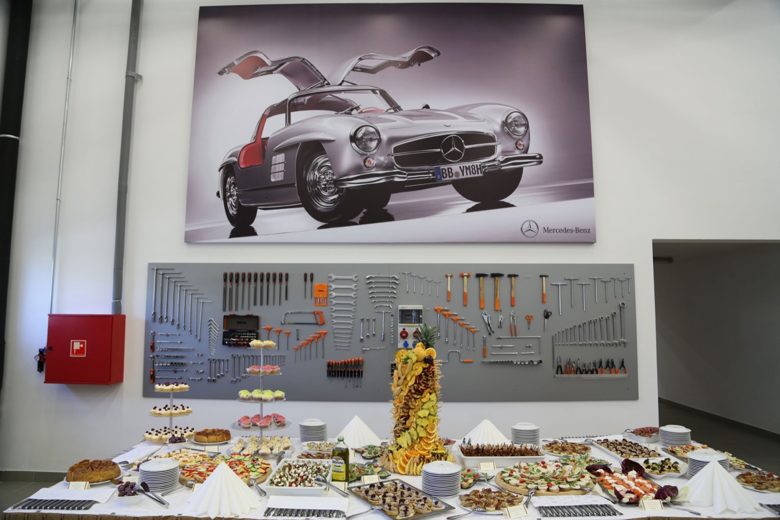 Food and drinks set out as a still life for the guests of the opening, in the workshop under the tool wall