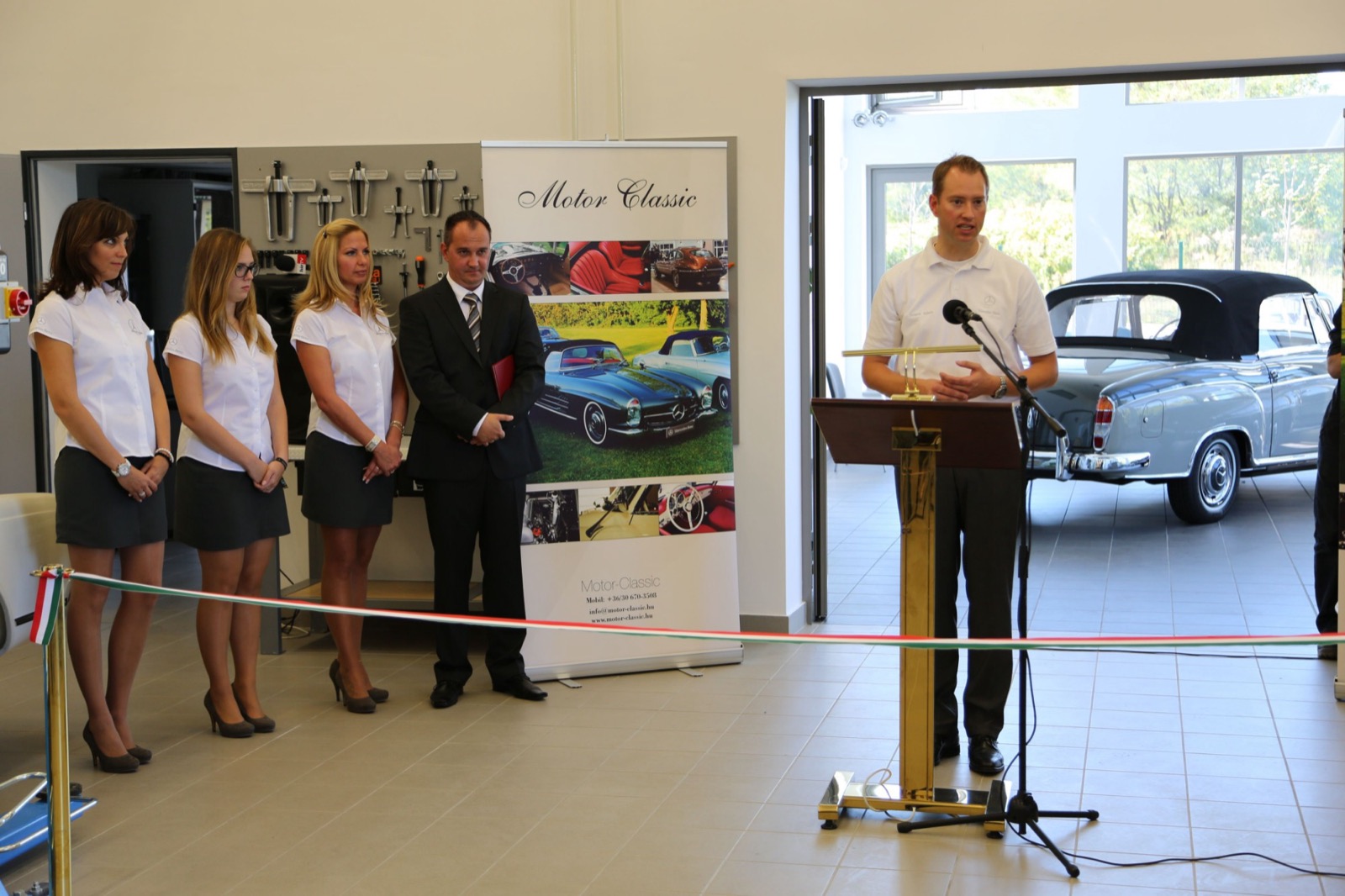 Speeches at the opening of the first workshop hall, with a classic Mercedes-Benz cabriolet in the background